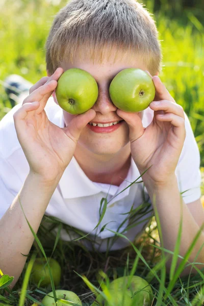 Adolescente chico es holding verde manzanas — Foto de Stock