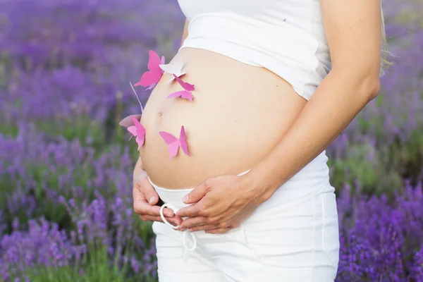 Jolie femme enceinte avec des papillons en papier sur le ventre — Photo