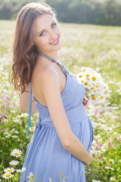 Mujer embarazada con ramo de flores de margarita —  Fotos de Stock