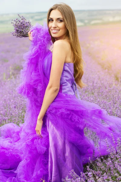 Mooi meisje draagt mode jurk op gebied van lavendel — Stockfoto