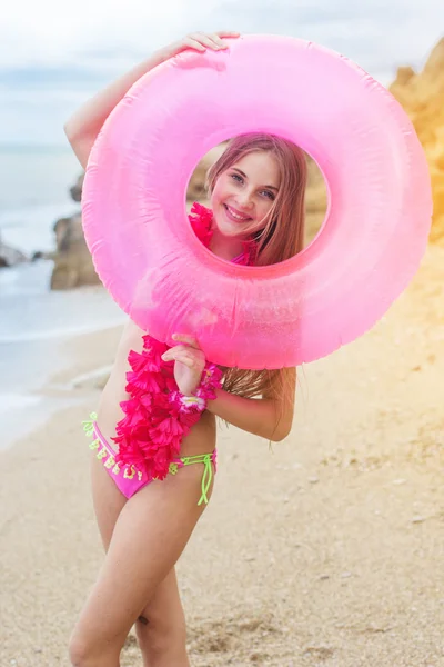 Child girl is wearing swimsuit with rubber ring at beach — Stock Photo, Image
