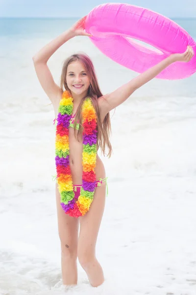 Chica está usando traje de baño con anillo de goma rosa en la playa — Foto de Stock