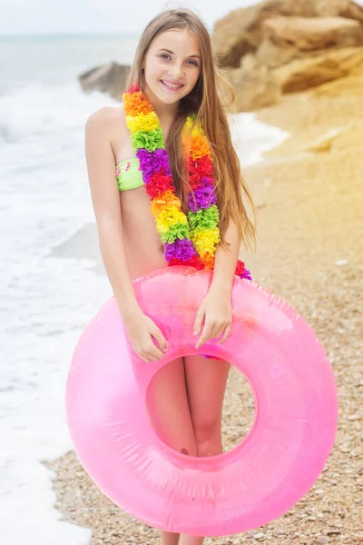 Милый ребенок в купальнике с резиновым кольцом на пляже — стоковое фото