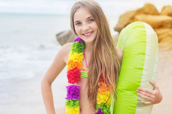 Дівчина в гавайських квітах з гумовим кільцем на пляжі — стокове фото
