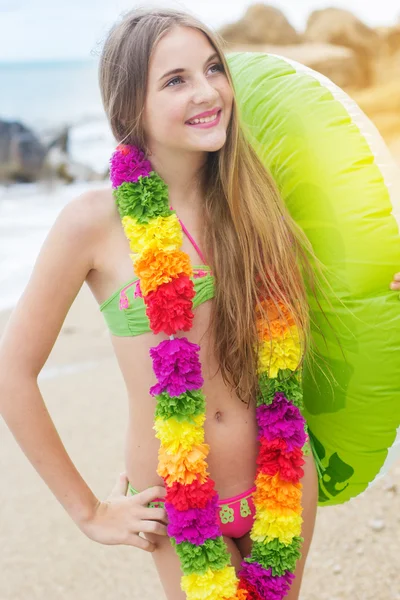 Girl is wearing hawaiian flowers with rubber ring at beach — Stock Photo, Image