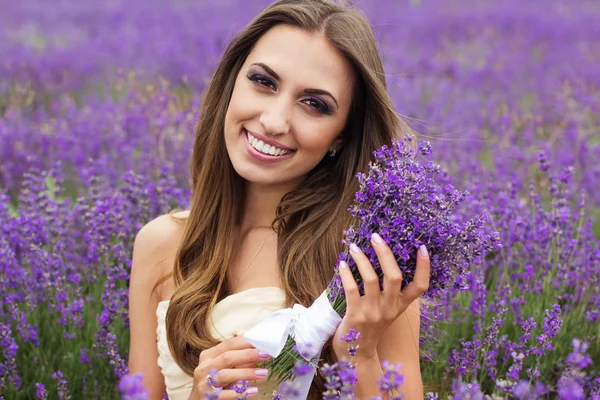Retrato de niña sonriente con maquillaje en el campo de lavanda púrpura —  Fotos de Stock