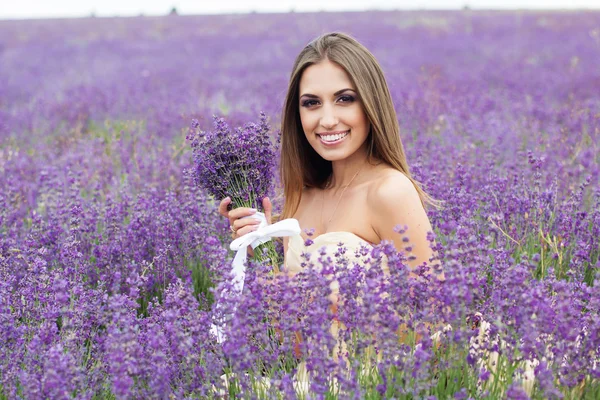 Porträt einer Braut mit Blumenstrauß im Lavendelfeld — Stockfoto