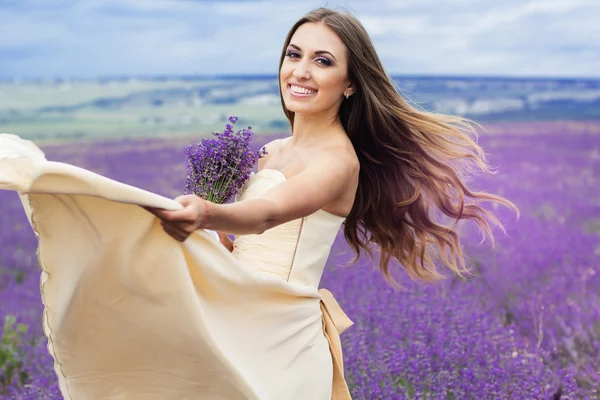 Porträt eines lächelnden Mädchens mit fliegendem Haar im Lavendelfeld — Stockfoto