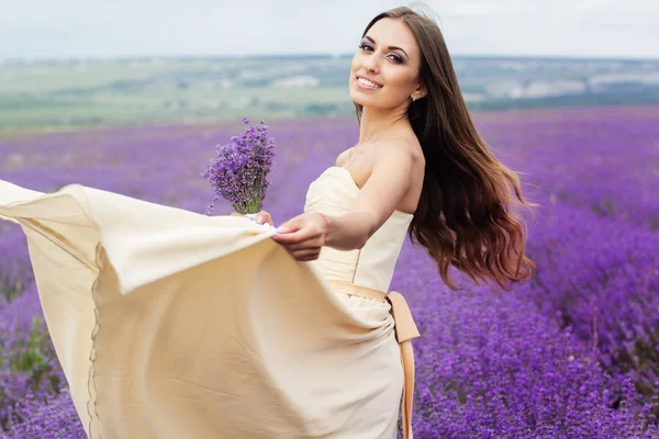 Pretty girl is wearing wedding dress at purple lavender field Stockfoto