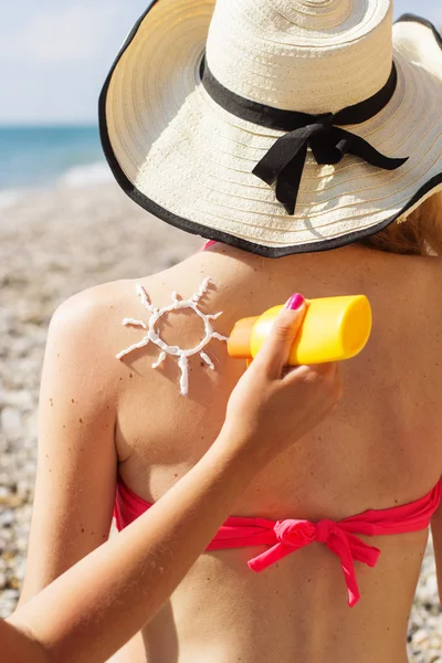 Amigo aplicando crema solar sobre mujer bronceada espalda —  Fotos de Stock