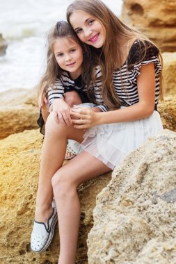 İki küçük kız kardeş kız sahilde oynarken