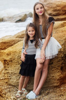 İki sevimli kız sahilde duran