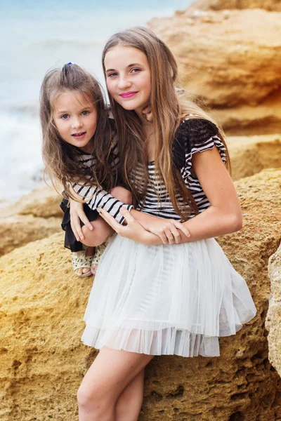 Retrato de dois amigos bonitos meninas sentadas na praia — Fotografia de Stock