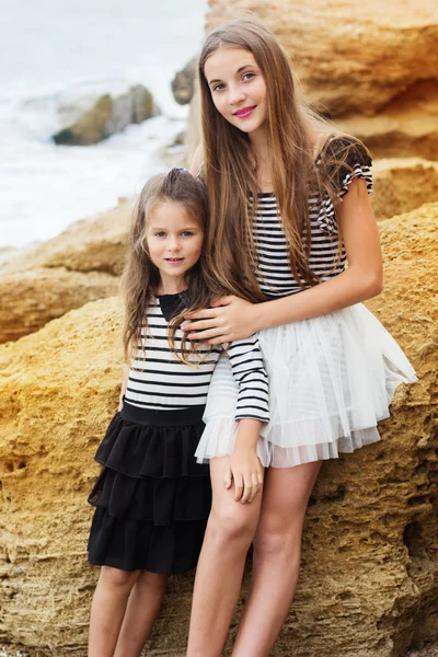 Portrait de deux jolies amies filles assises sur la plage — Photo