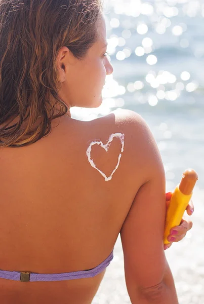 Imagen de primer plano de la loción bronceadora protector solar en la espalda de la mujer —  Fotos de Stock