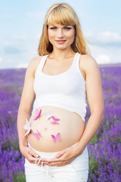 Velmi těhotná žena s motýly v břiše — Stock fotografie