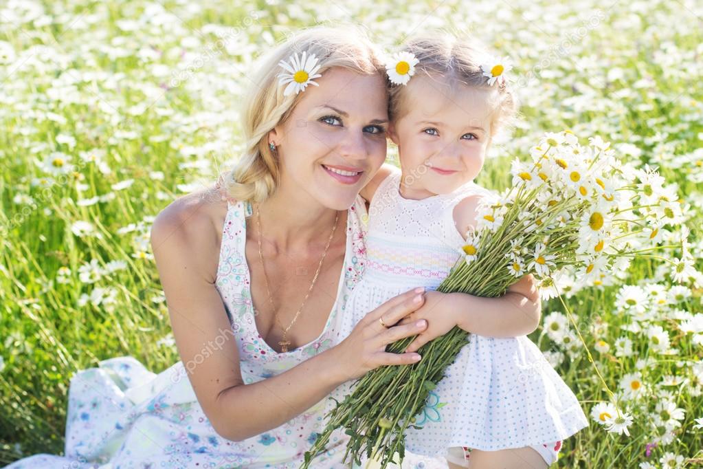 Mother and daughter in a field of daisy flowers