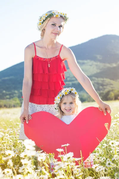 Happy sisters are holding red paper heart — Stock Photo, Image