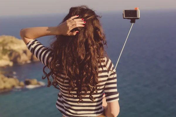 Туристическая девушка делает селфи фото с палкой в горах путешествия — стоковое фото