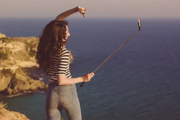 Туристическая девушка делает селфи фото с палкой в горах путешествия — стоковое фото