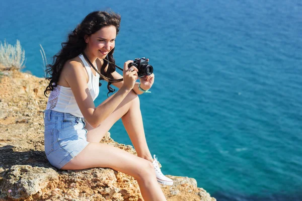 Photographer girl making pictures by old camera on mountain top — Stockfoto