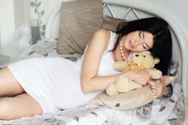 Güzel bir hamile kadın yatakta yatarken