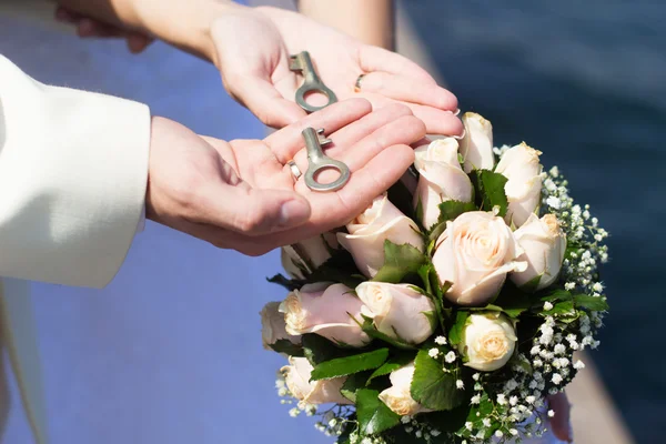 Novia y novios manos con llaves, día de la boda — Foto de Stock