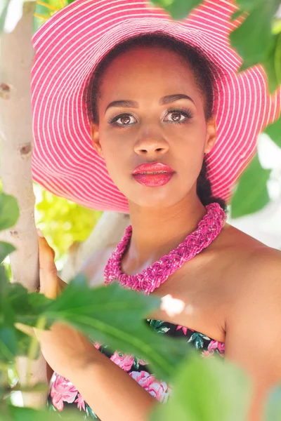 Menina sul-africana está usando chapéu rosa em folhas verdes — Fotografia de Stock