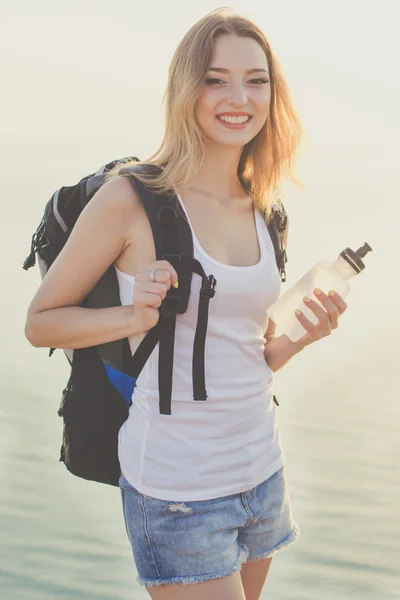 Leende backpacker flicka håller vattenflaska — Stockfoto