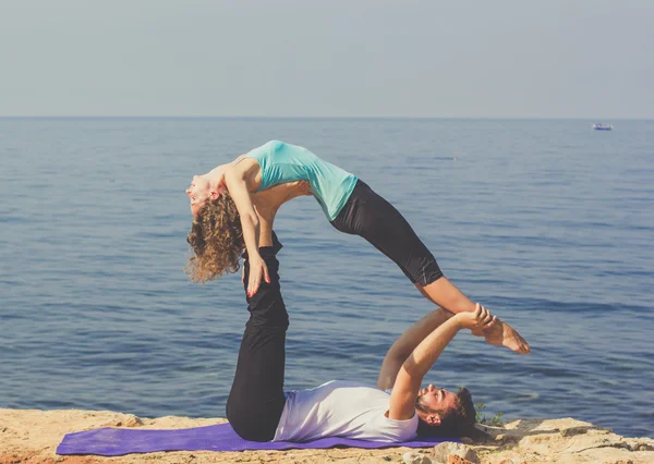 Çift acroyoga deniz kıyısında pratik vardır — Stok fotoğraf