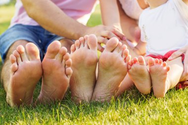Closeup photo of feets lying in line at green grass