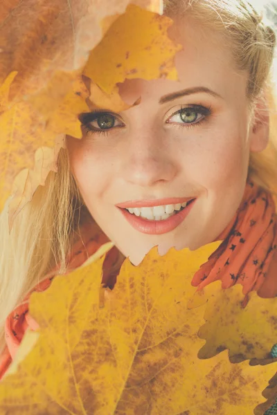 Cara de niña con hojas de arce amarillo — Foto de Stock