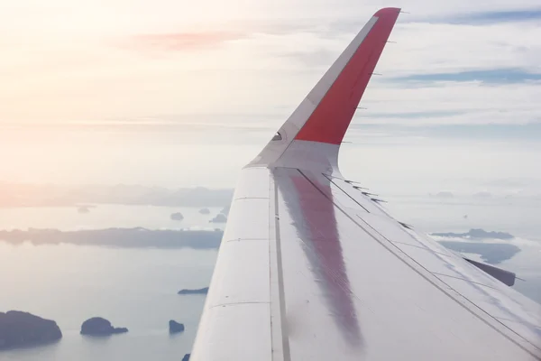 Ala de um avião voando no céu, de manhã cedo — Fotografia de Stock