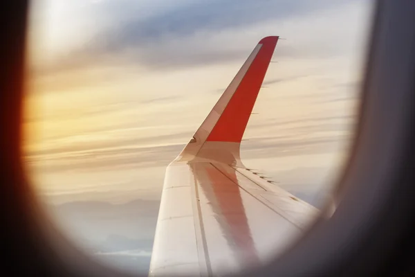 Крыло самолета, летящего в небе ранним утром — стоковое фото