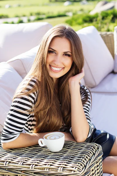 Mooie vrouw drinken koffie in een café glimlachen — Stockfoto