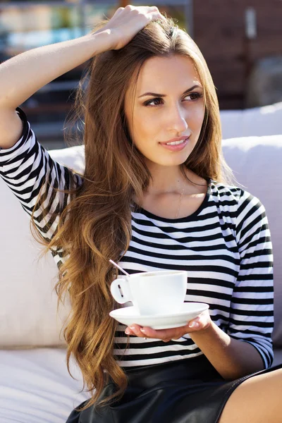 Mooie vrouw drinken koffie in een café in de buitenlucht — Stockfoto