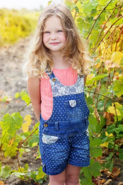 Blonde curly child girl in grape garden — Stock Photo, Image