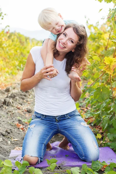 Moeder houdt zoon op schouders, herfst tijd — Stockfoto