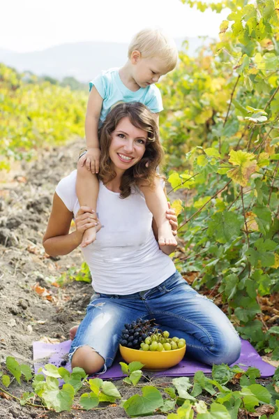 Moeder met zoon in druiven wijngaard — Stockfoto