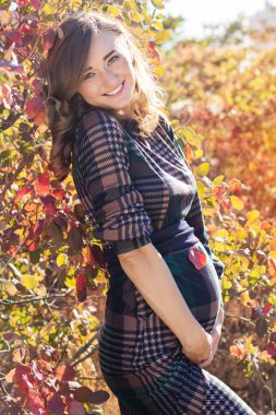 Sonbahar parkta hamile genç gülümseyen kadın