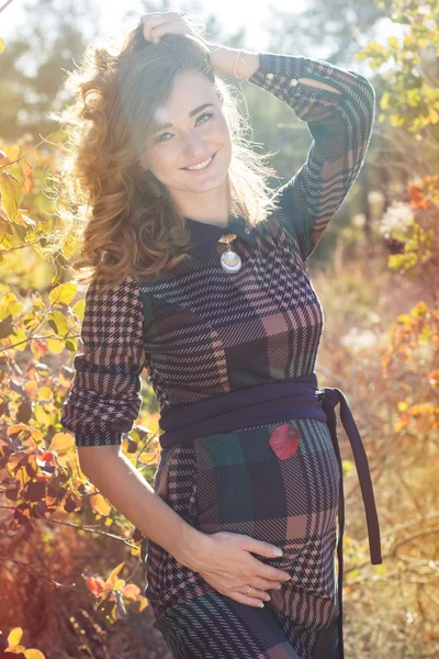 Young pregnant pretty girl in the autumn park — Stock Photo, Image