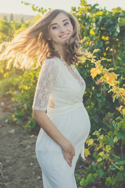 Lykkelig, gravid kvinne i høstvingården – stockfoto