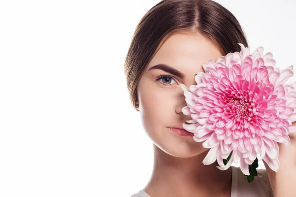 Jong meisje met chrysant bloem op halve gezicht — Stockfoto