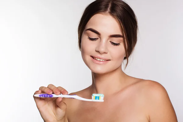 Adolescente chica está sosteniendo cepillo con pasta de dientes — Foto de Stock