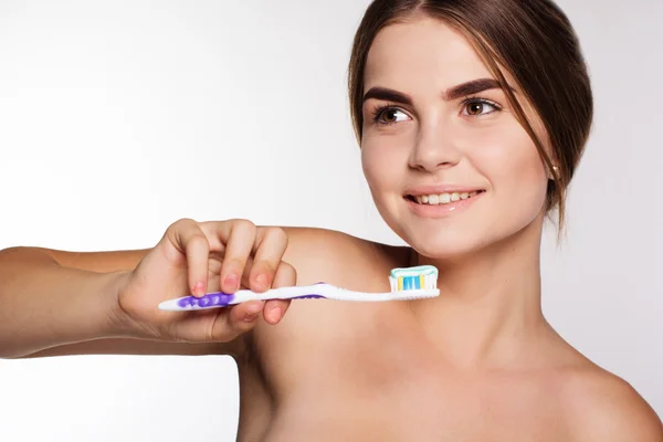 白い歯を持つ少女は、歯ブラシを保持しています。 — ストック写真