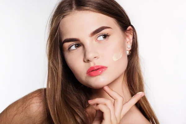 Menina está aplicando creme facial hidratante — Fotografia de Stock