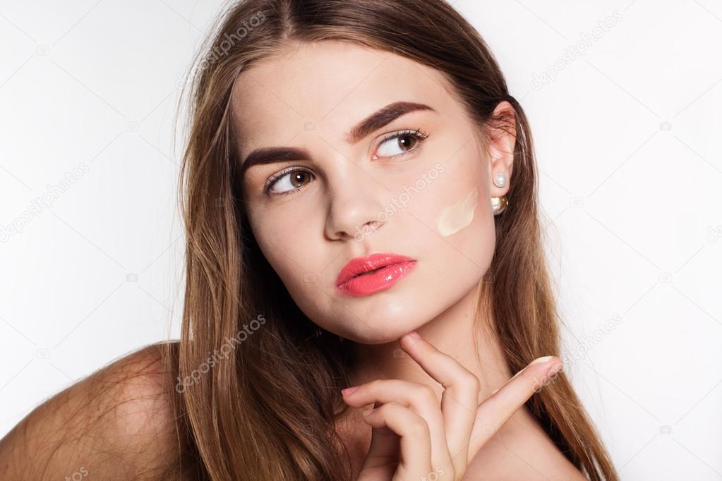 Girl is applying moisturizing facial cream