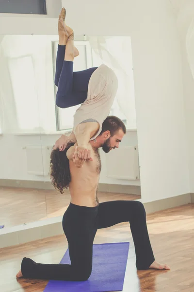 Sportive couple are doing acro-yoga exercises — Stockfoto