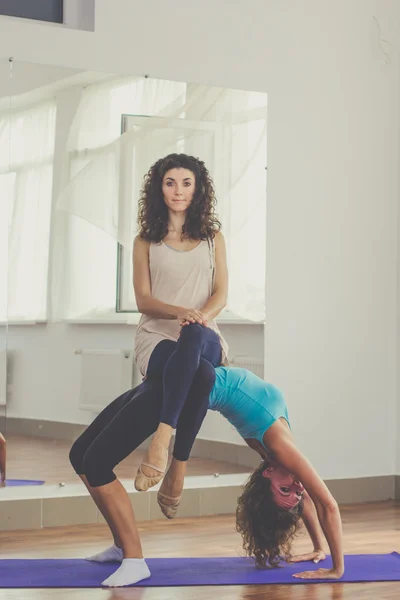 Two slim girls are doing acroyoga in studio — Stok fotoğraf