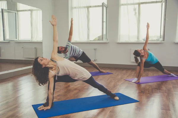 Group of people are doing yoga indoors — Stok fotoğraf